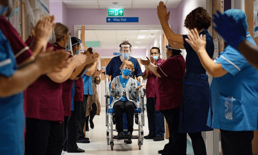 Margaret Keenan, 90, is applauded by staff as she returns to her ward after becoming the first person to receive the Pfizer-BioNtech Covid-19 vaccine at University Hospital in Coventry in the UK on December 8 (Photo: JACOB KING/POOL/AFP via Getty Images) 
