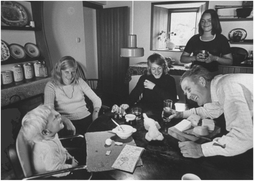 Black and white photograph of family laughing at kitchen table
