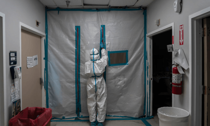 A health worker exits the COVID-19 intensive care unit on New Year’s Day at the United Memorial Medical Center in Houston, Texas. (Photo by Go Nakamura/Getty Images) 

