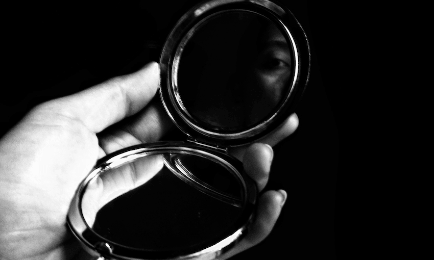 Cropped Hand Of Woman Holding Mirror Against Black Background