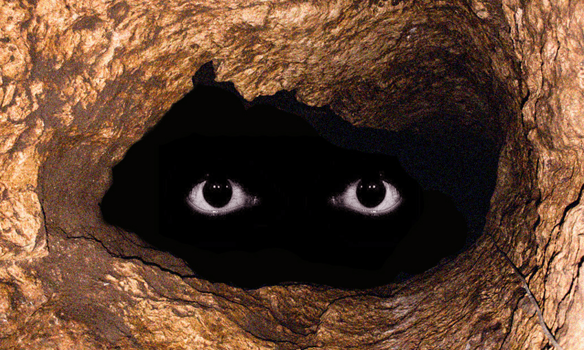 a deep, dark cave with a pair of scary eyes floating in it