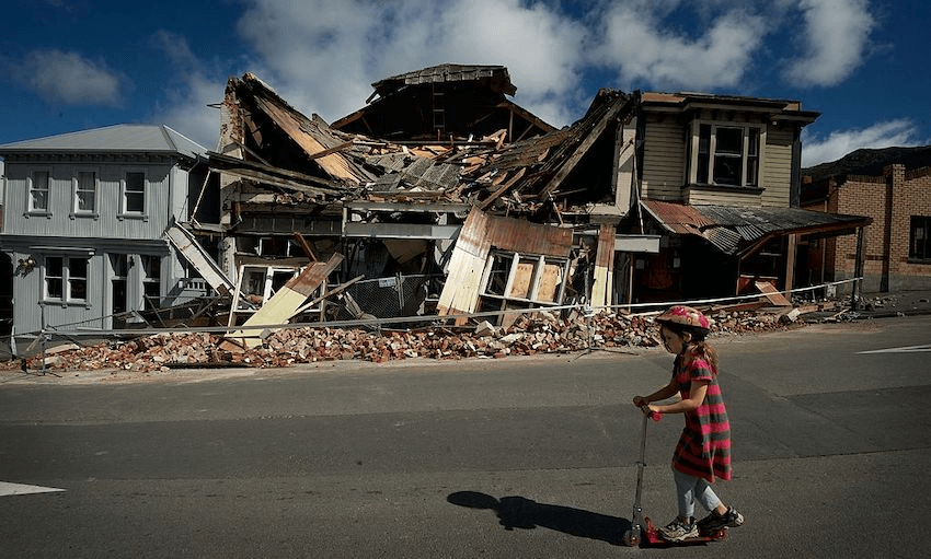 Scarlett Corbett, 7, rides past the damaged theatre in the center of Lyttleton after the 6.3 magnitude earthquake, on February 24, 2011 in Christchurch. (Photo: Fairfax Media/Getty Images) 
