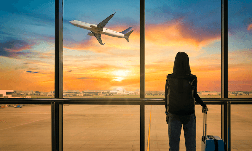 Silhouette of person standing watching passenger jet take off into sunset