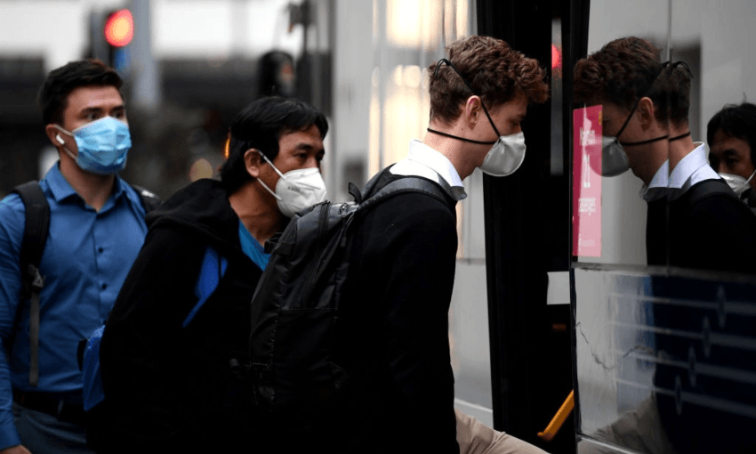 People getting on a bus in Auckland wearing masks (Getty Images)