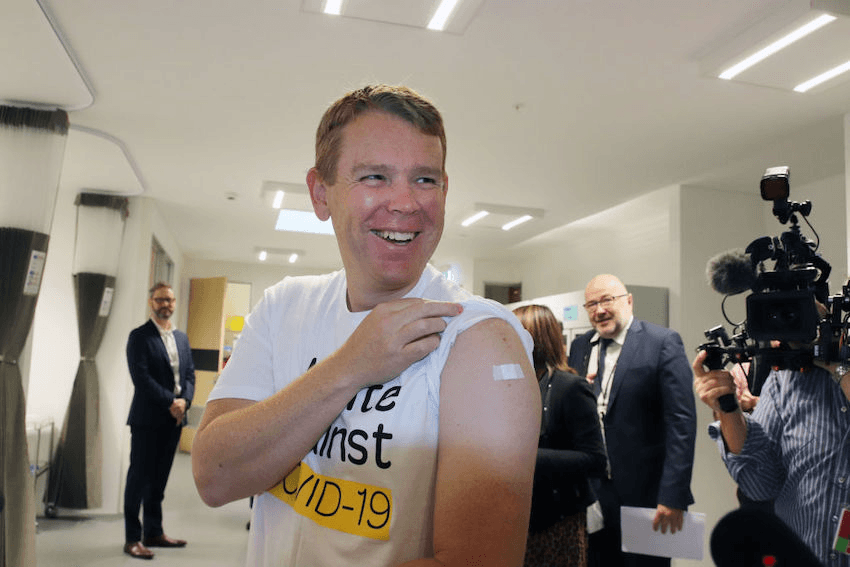 Chris Hipkins shows reporters where he received the Pfizer Covid-19 vaccine (Photo by Lynn Grieveson – Newsroom/Newsroom via Getty Images) 

