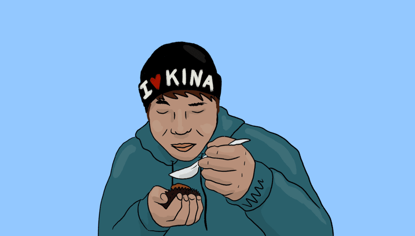Illustration of a person eating kina, wearing a beanie that says "I heart kina". Illustration by Gabrielle Baker