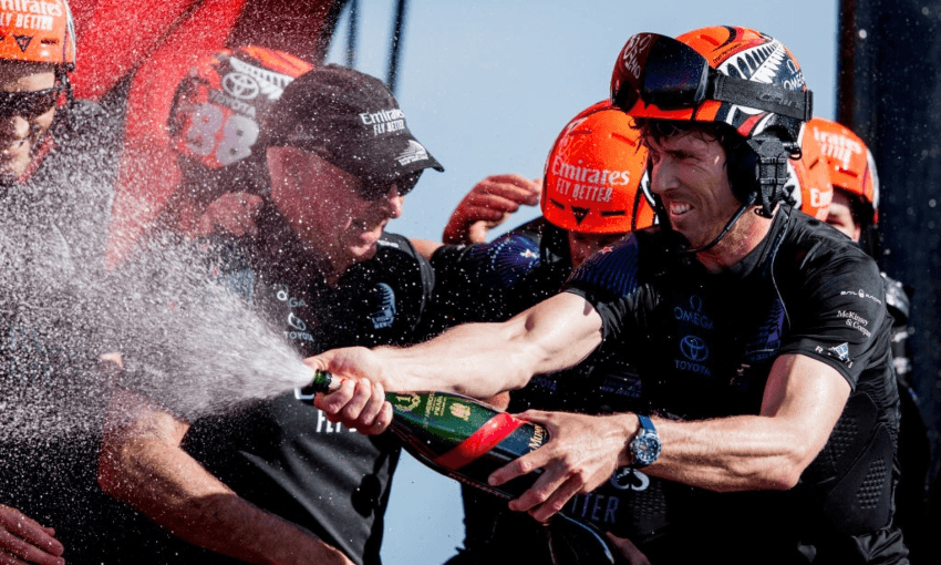 Peter Burling spraying champagne after winning the America’s Cup (Getty Images) 
