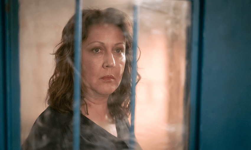 Rima Te Wiata as Susan Armstrong, gazing through the small window of a jail cell door.