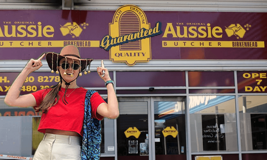 Author, wearing cork hat, points up at Aussie Butcher sign.