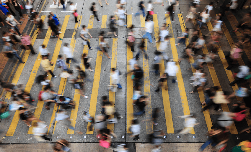 Crowds of people crossing a busy street