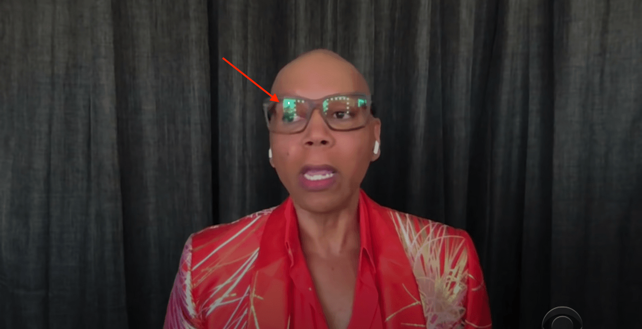 RuPaul in front of curtains with an arrow pointing to the reflection