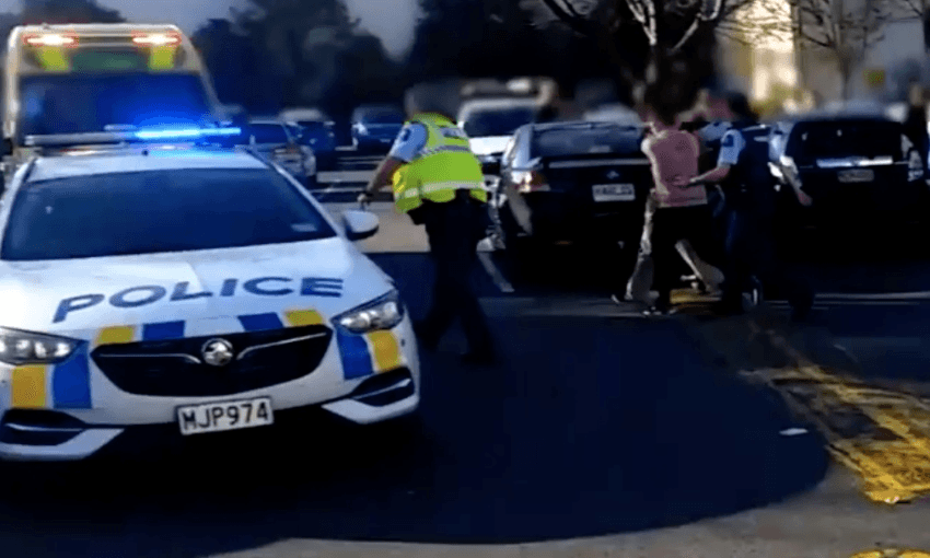 Image: The alleged Dunedin supermarket attacker being led away by police (Radio NZ)