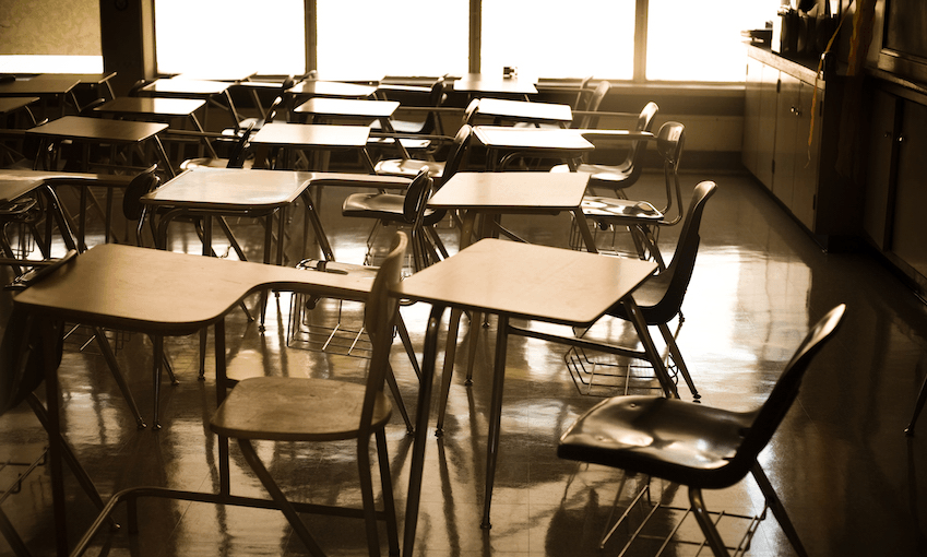 An empty classroom, desks and chairs, weird late afternoon light.