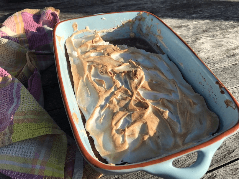 A meringue-topped pudding on an outdoor table