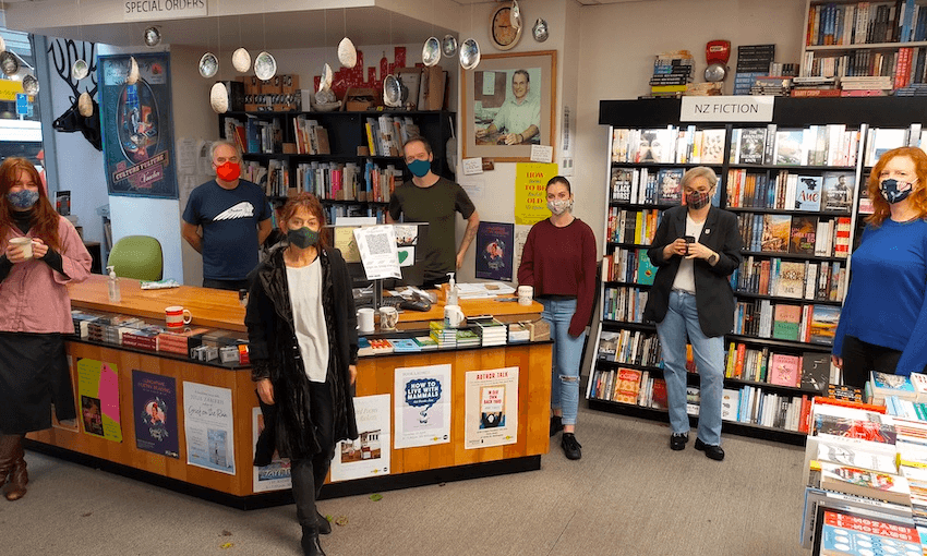 A bookstore, with seven masked staff standing facing camera