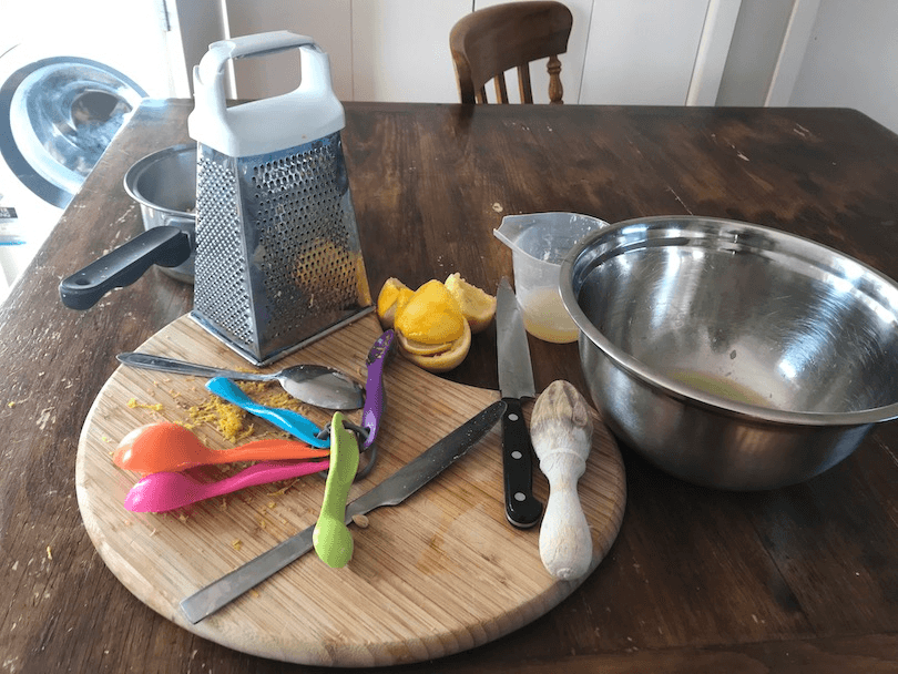 Cooking utensils and lemon skins on table