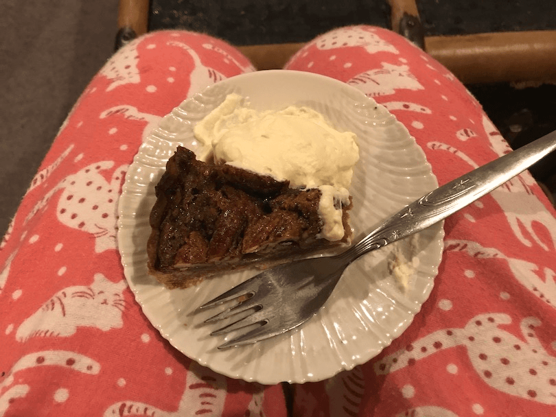 A slice of pie on a lap, the person is wearing pink pyjamas
