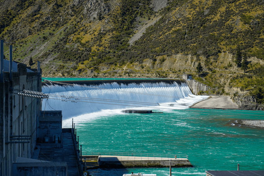 green water and a big curving dam with a cascade of water trickling through it