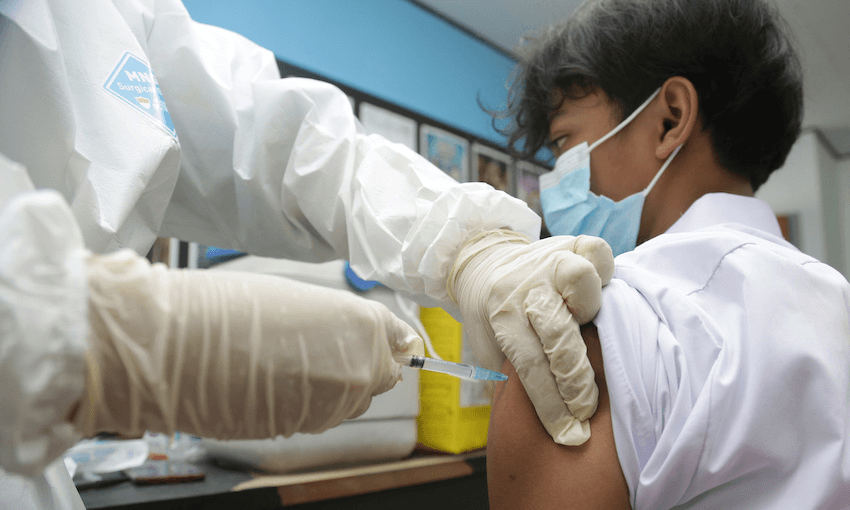 A student in Jakarta receives a Covid-19 vaccine on August 3. Covid is running rampant in Indonesia, which has full vaccination rates of just 7.6% (Photo: Kuncoro Widyo Rumpoko/Pacific Press/LightRocket via Getty Images) 
