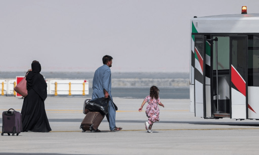 A family from Afghanistan board an airport shuttle bus after arriving in the UAE. Photo by Giuseppe CACACE / AFP 
