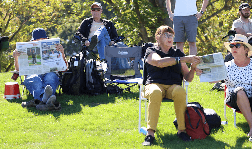 Boomers on lawn chairs read The Press, bright green grass, beaut day
