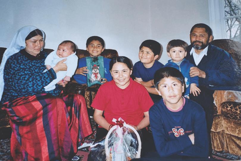 Family group photo taken inside a home, six children and Mum and Dad