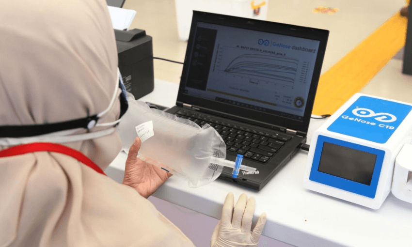 Officers carry out an inspection with an Electronic Nose, a rapid detection tool for Covid-19 from breath, at Pasar Senen Station, Jakarta. (Photo by Dasril Roszandi/Anadolu Agency via Getty Images) 
