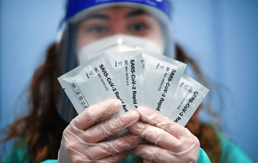 A German pharmacy worker hold up rapid antigen test kits. (Photo: INA FASSBENDER/AFP via Getty Images) 
