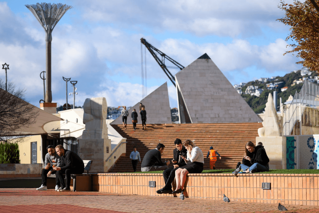 WELLINGTON, NEW ZEALAND – JUNE 28: People sit down for lunch in Civic Square during alert level 2 on June 28, 2021 in Wellington, New Zealand. The Wellington region is in alert level 2 until 11.59pm on Tuesday while the rest of the country is at level 1 following the emergence of new COVID-19 cases in New Zealand linked to a cluster outbreak in Sydney, Australia. (Photo by Hagen Hopkins/Getty Images) 
