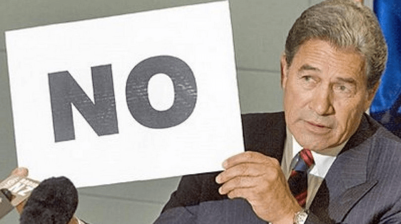 winston peters holding up a sign that says "no"