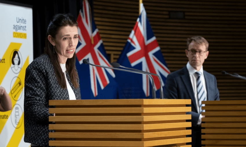 Jacinda Ardern and Ashley Bloomfield outline the new decisions at the Beehive theatrette on Monday October 4. (Photo by Mark Mitchell – Pool/Getty Images) 
