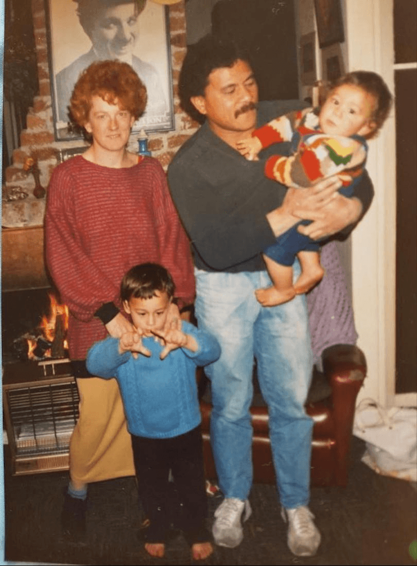 Old family photo of a young couple with a preschooler and a baby, both looking like mischief. Taken in the 80s. 