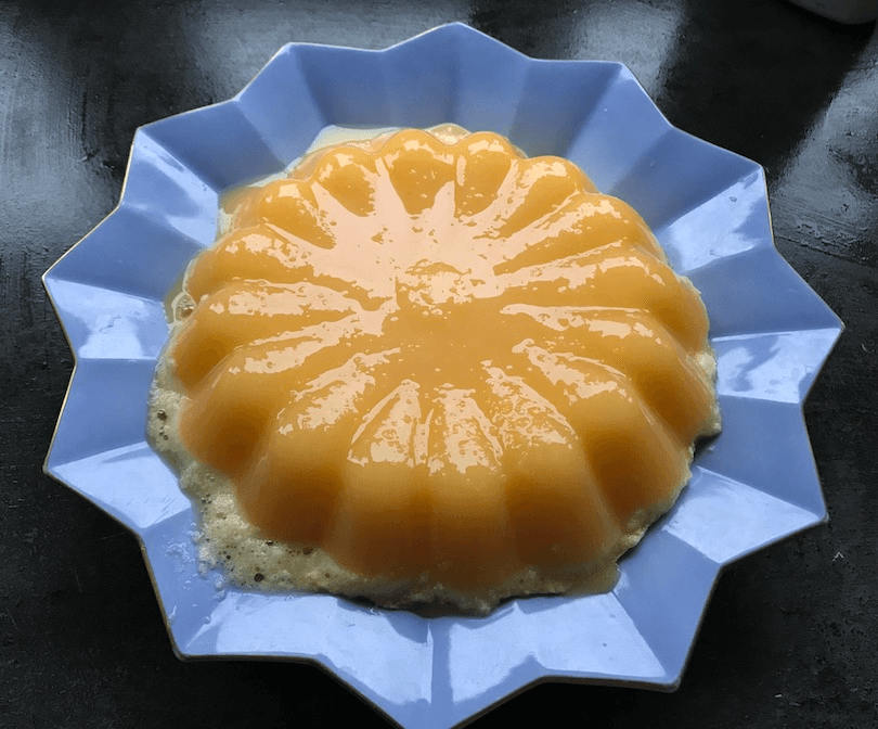 Glossy orange jelly on a blue star-shaped plate. 