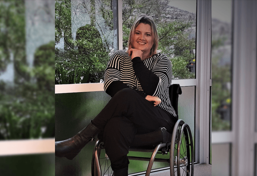 Juliana Carvalho smiling, sitting in wheelchair