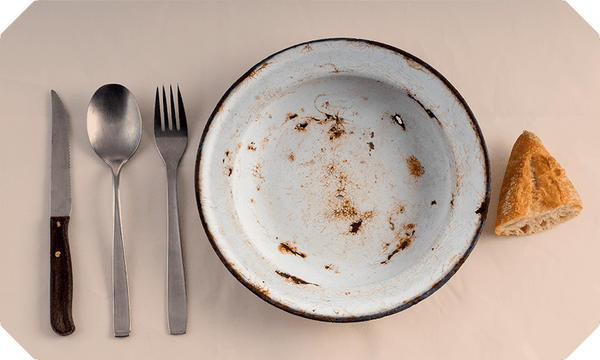 Empty plate with cutlery and a piece of bread
