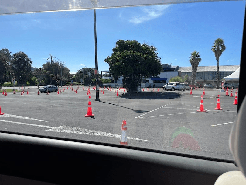 Blue sky over an empty carpark, lots of road cones.