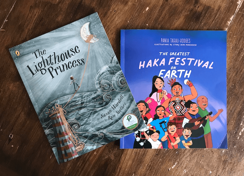 Photograph of two picture books, one in grey and brown tones, the other bright blue.