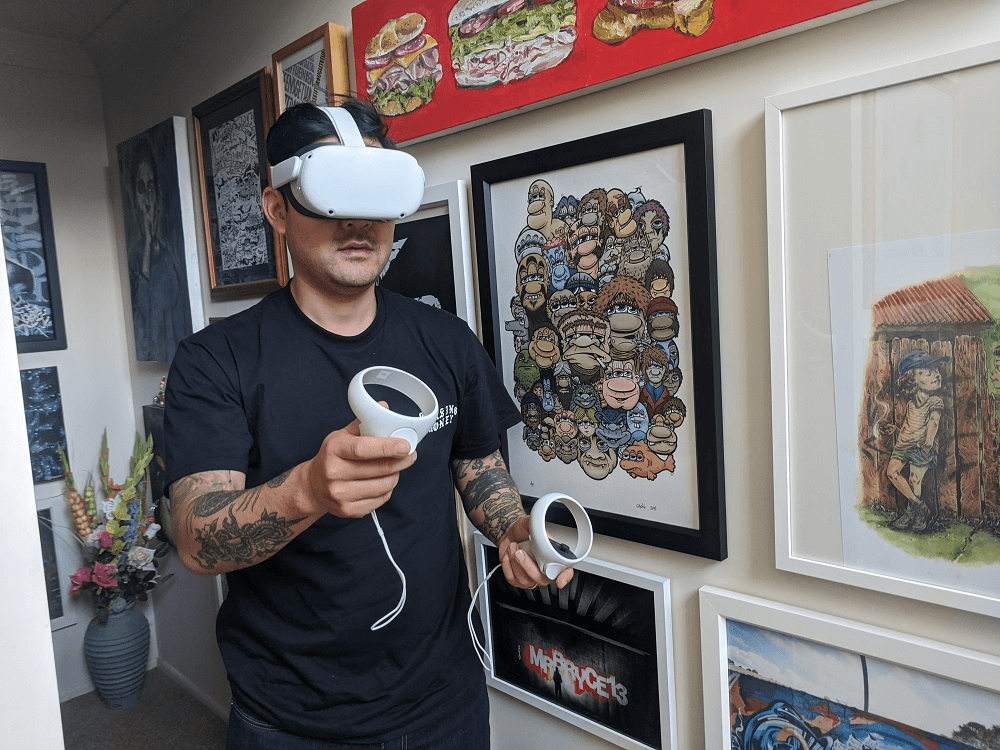 bobby hung wears a VR headset in a hallway lined with pieces of art 