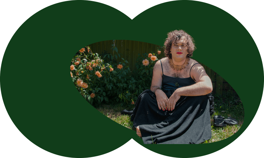 Photo shows the author sitting in a garden, wearing a long black dress with spaghetti straps. Orange dahlias and purple wisteria behind.