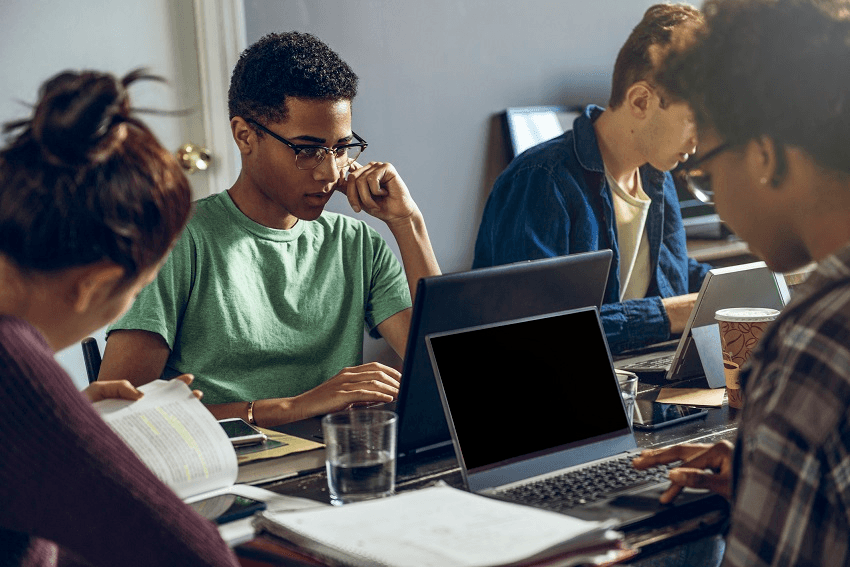 Female and male friends studying together in living room - stock photo