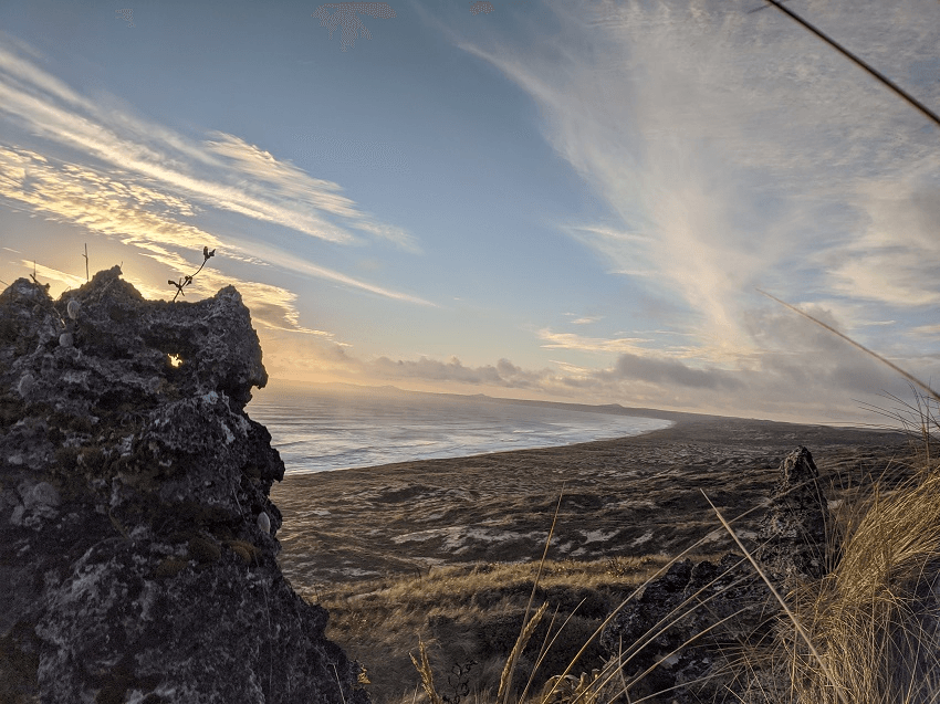 a long empty beach with streaks of shiny gold clouds. very veautiful and peaceful looking