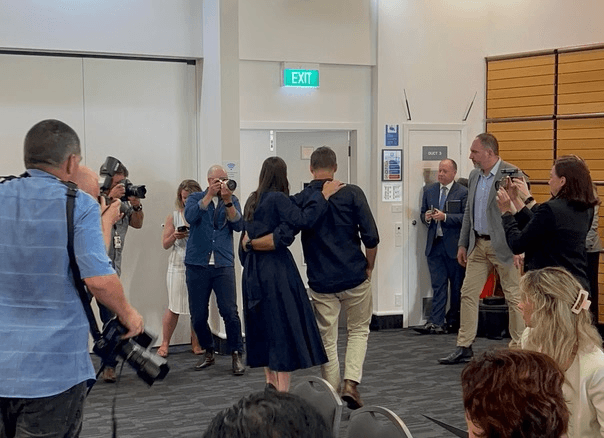 Jacinda arden walking with her back to the camera and people around her