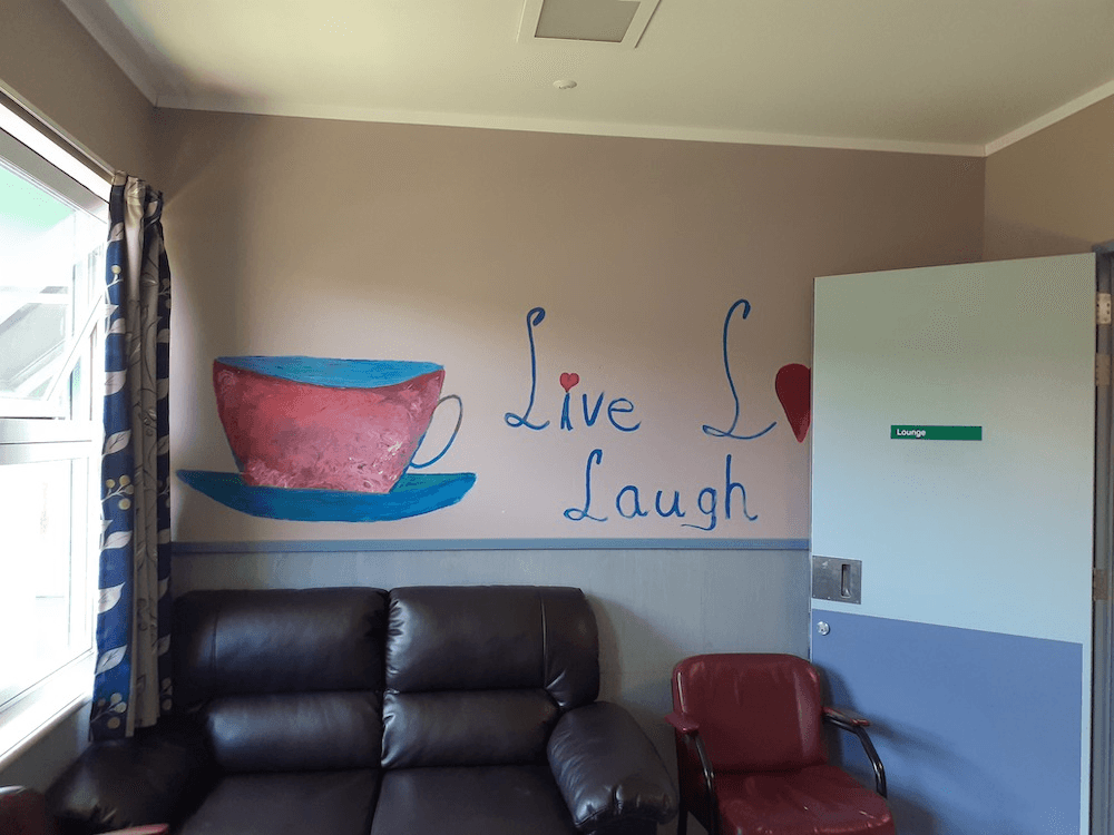 A photo of the women's lounge at the psych ward, with a not so inspirational inspirational quote on the wall.