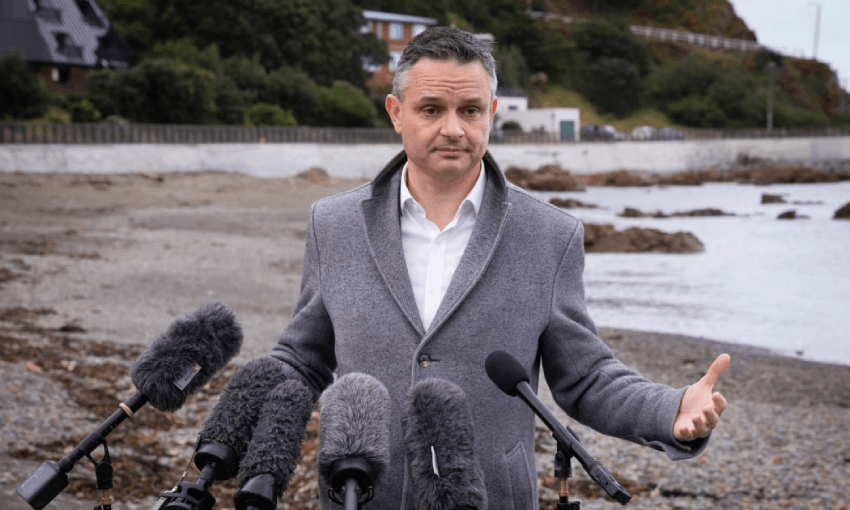 James Shaw on a beach surrounded by water and microphones