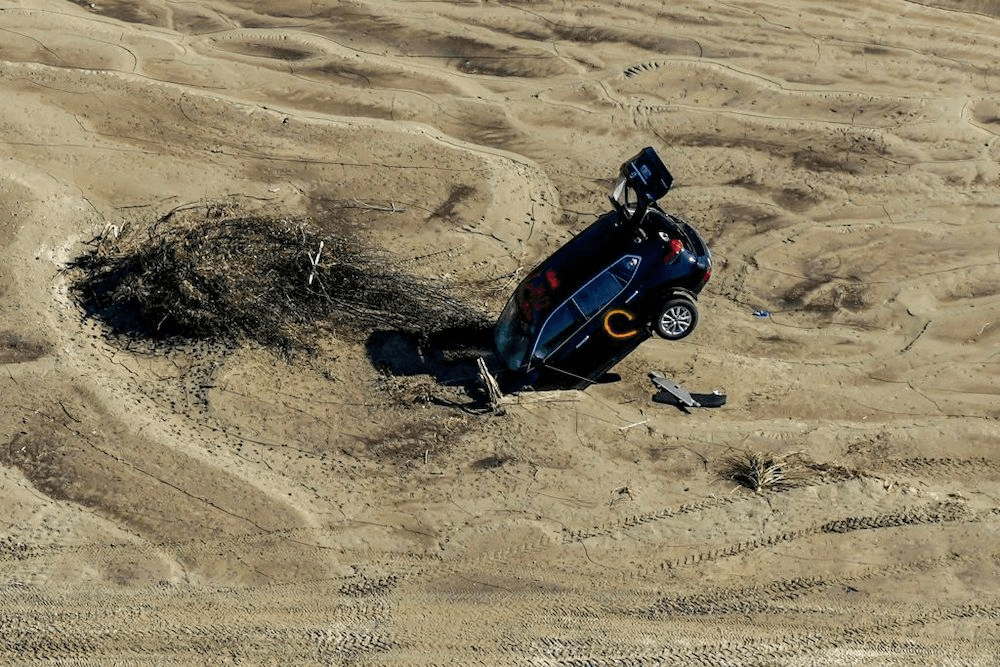 A car is seen stuck in the sand in the aftermath of Cyclone Gabrielle in the Esk Valley near Napier. Photo: Getty 
