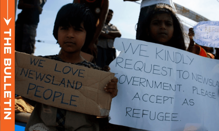 The image shows two Sri Lankan children who are asylum seekers hold signs and pleading for assistance from the New Zealand onboard the MV Alicia in 2011