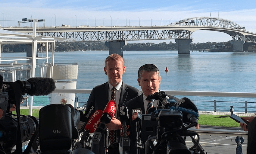 Chris Hipkins and Michael Wood stand in front of Auckland's Harbour Bridge.
