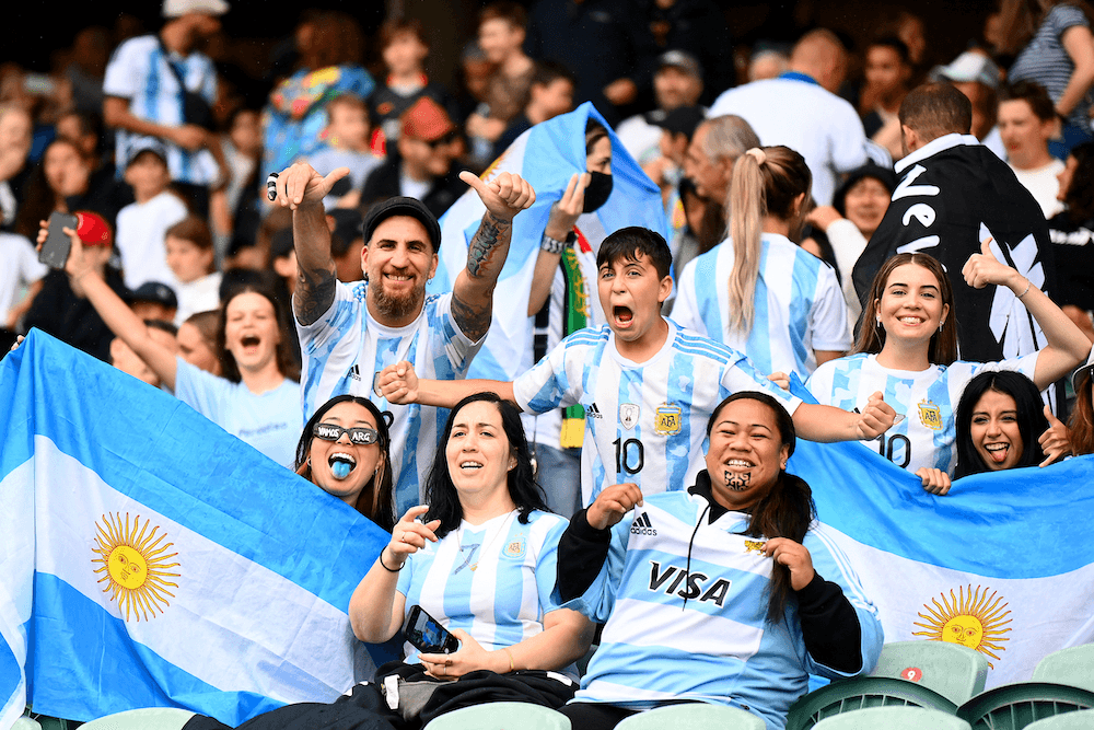 fans wearing argentina football jerseys and holding flags