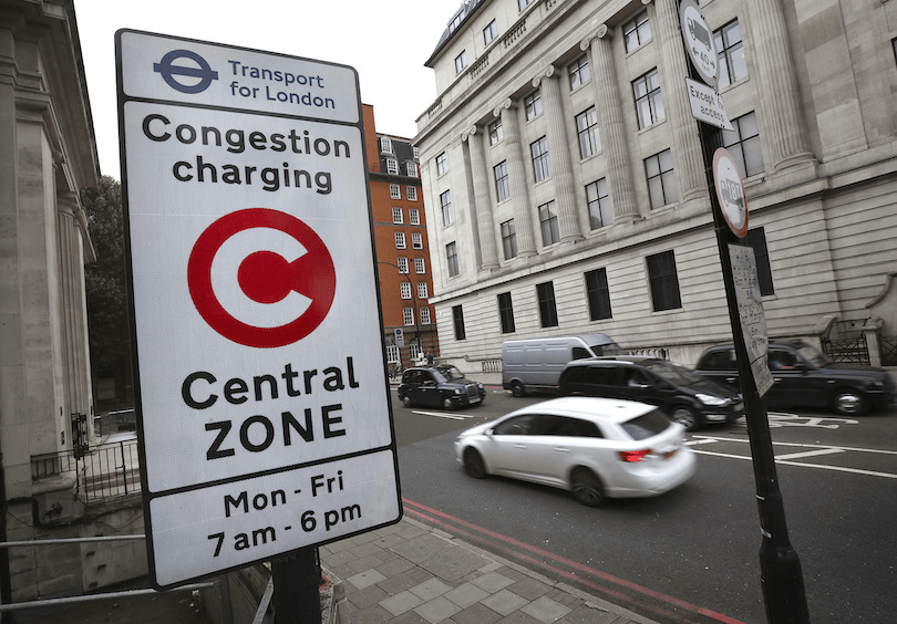 A central London street scene with a congestion charge sign in the foreground
