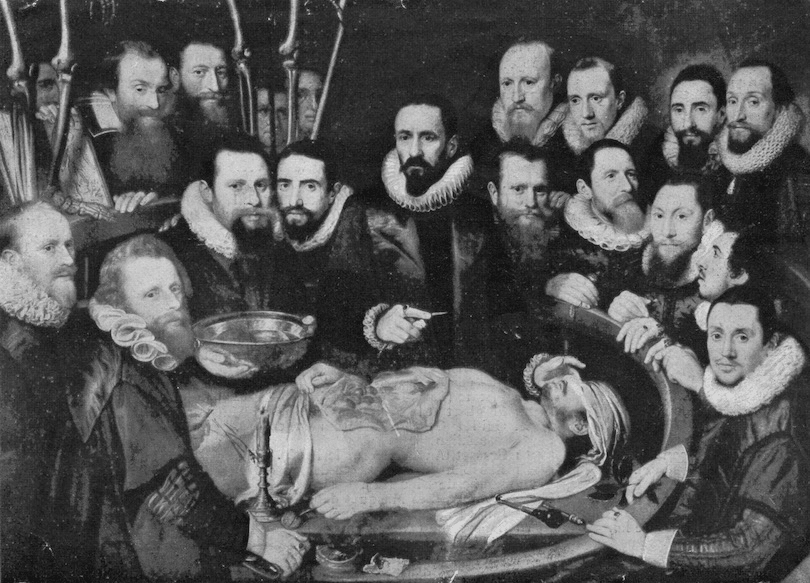 A group of men crowded around a cadaver, holding scalpels